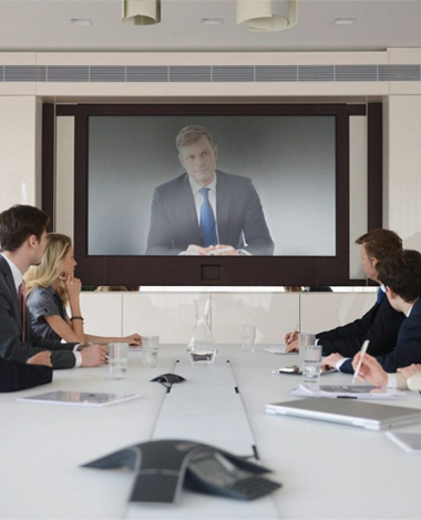 Business team watching a presentation on a large screen in a conference room.